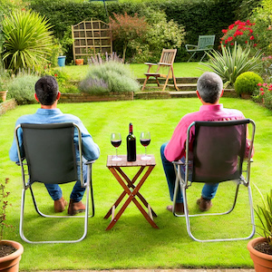 Two men sitting in a backyard, sharing ideas over drinks